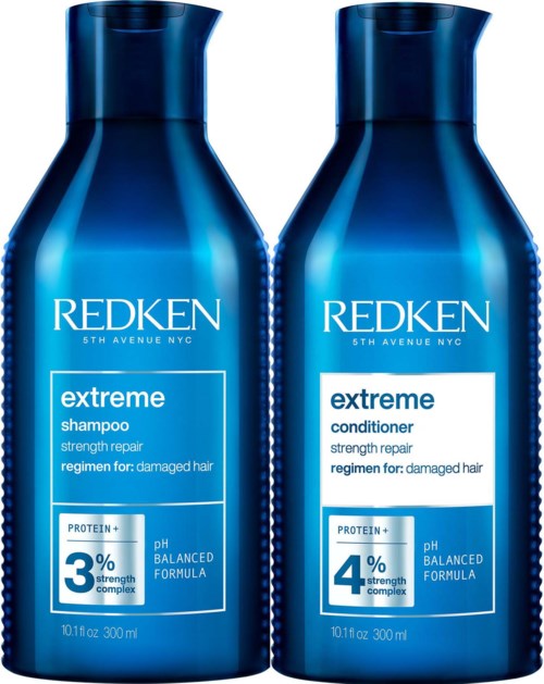 Twee blauwe flessen Redken haarverzorgingsproducten, shampoo en conditioner, voor beschadigd haar, met versterkingslabel.