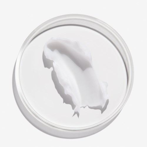 Een ronde container bevat witte crème met een glad oppervlak en een licht gerimpeld uiterlijk.