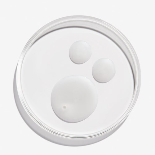 Drie witte pillen van verschillende grootte in een doorzichtige container, gerangschikt als een lachend gezicht.