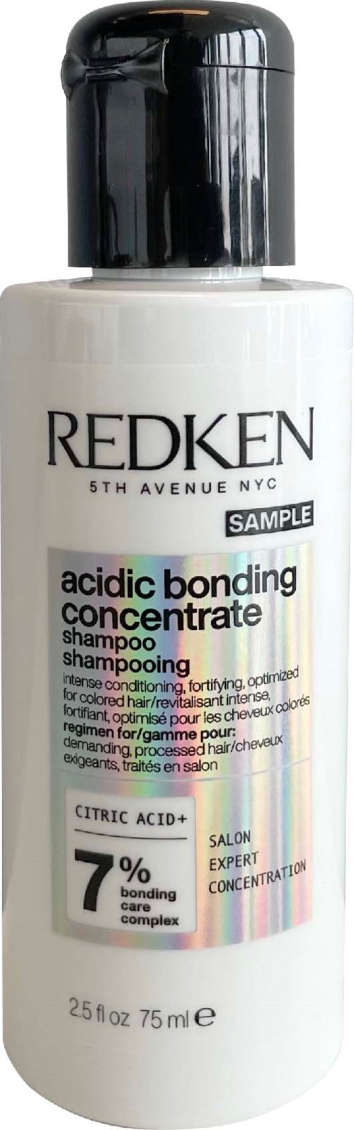 En vit flaska av Redken syra bindning schampo med svart lock och färgglad etikett som beskriver ingredienser och varumärke.