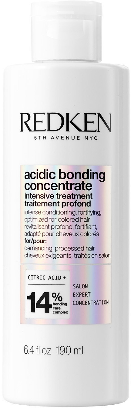 Een witte fles Redken haarbehandeling met een gedetailleerd label dat het gebruik en de ingrediënten beschrijft.