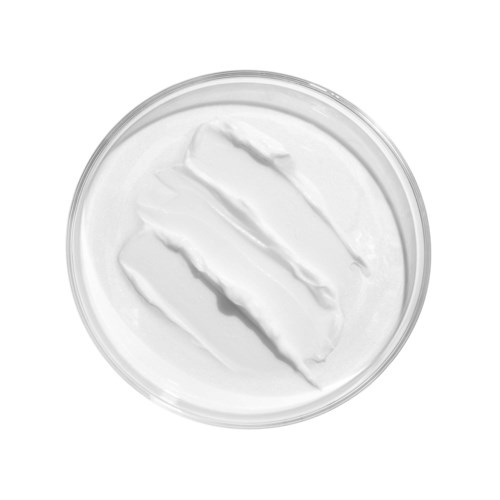 Een ronde container gevuld met witte crème of lotion met diagonale strepen bovenop.