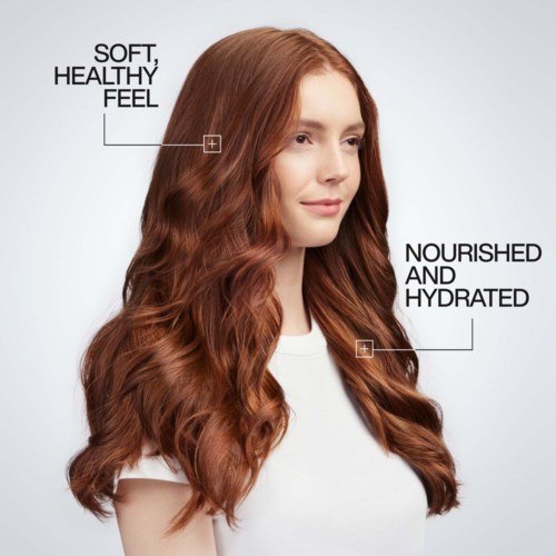 Girl with long, wavy red hair, smiling slightly, white top, mentions soft feel and hydrated hair.