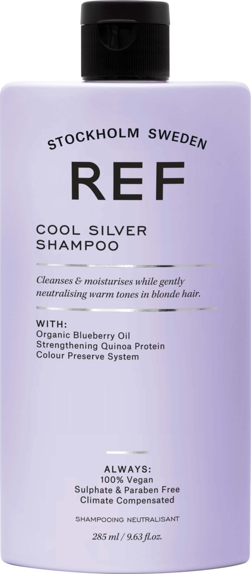 Een witte shampoefles met zwart deksel, gemarkeerd met 'REF', bevat details over ingrediënten en voordelen voor blond haar.