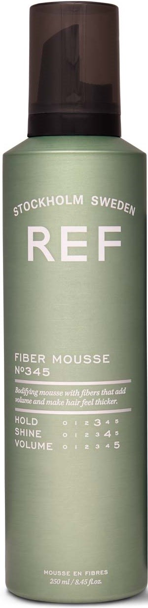 A green spray bottle with black cap, labeled 'REF FIBER MOUSSE' from Stockholm, Sweden, with instructions for styling hair.