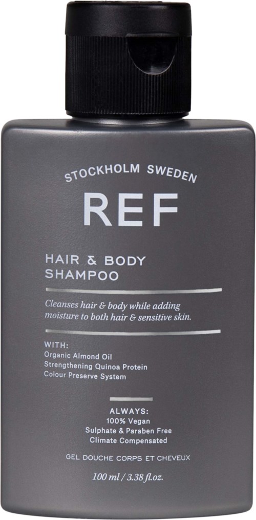 Eine graue Flasche REF Shampoo, das Haare und Körper reinigt, mit schwarzem Deckel und weißen Text.