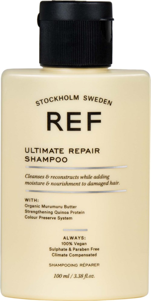 Eine beige Flasche mit REF-Shampoo, schwarzem Deckel und Etikett, enthält Haarreparatur und Pflege.