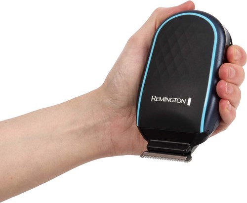 En hånd som holder en svart Remington elektrisk skjærer med blå detaljer, designet for hårklipping.