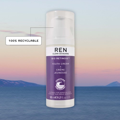 Een witte en paarse huidverzorgingsfles met label REN Bio Retinoid Youth Cream, met een hemel en water achtergrond.