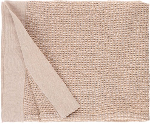 En beige teksturert håndkle med en glatt kant og ett hjørne lagt over.