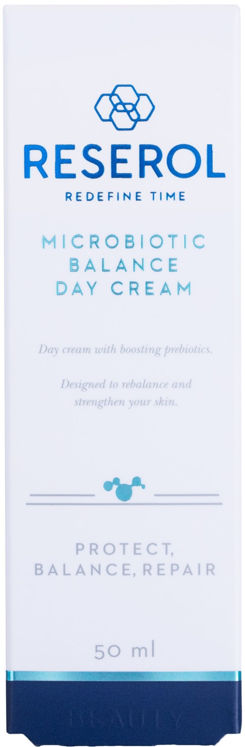 Een lange, witte cosmeticaverpakking met blauwe tekst en een logo bovenaan, beschrijft een dagcrème voor huidbalans en bescherming.