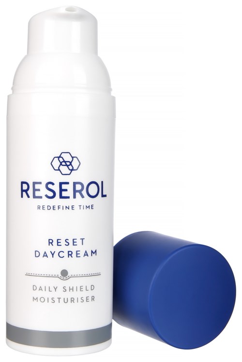 Een witte fles Reserol Reset Day Cream met een blauwe dop ernaast.