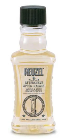 En liten klar flaske med Reuzel aftershave, grønt lokk og hvit etikett som viser produktdetaljer.