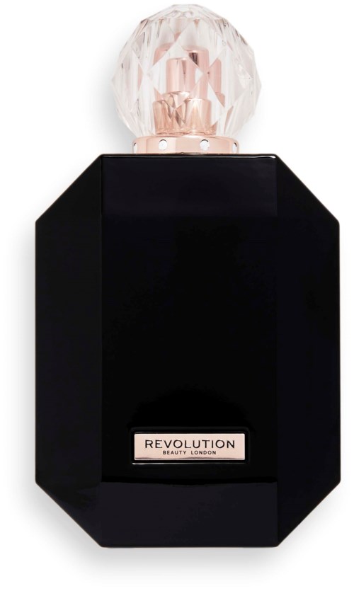 En svart parfymflaska med ett stort, klart, juvel-liknande lock och en etikett som säger 'REVOLUTION BEAUTY LONDON.'