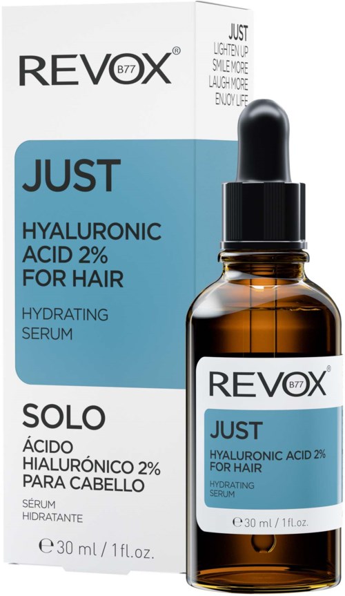 En brun glasflaska med svart droppkork och vit etikett, bredvid förpackningen. Det är Revox Just Hyaluronsyraserum.