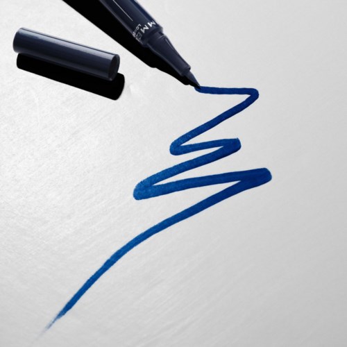 Blue marker draws a zigzag line on white paper.