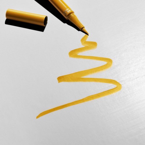A yellow marker draws a zigzag line on a white surface.