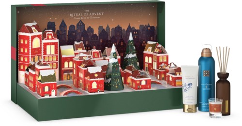 Juhlava adventtikalenteri, jossa pieniä koristeellisia rakennuksia, puita ja numerollisia ovia. Sisältää kylpytuotteita ja tuoksutikkuja.