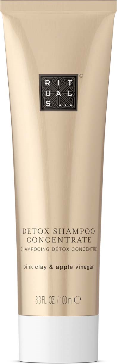A beige tube of detox shampoo with black and white logo, labeled as concentrating on pink clay and apple vinegar.