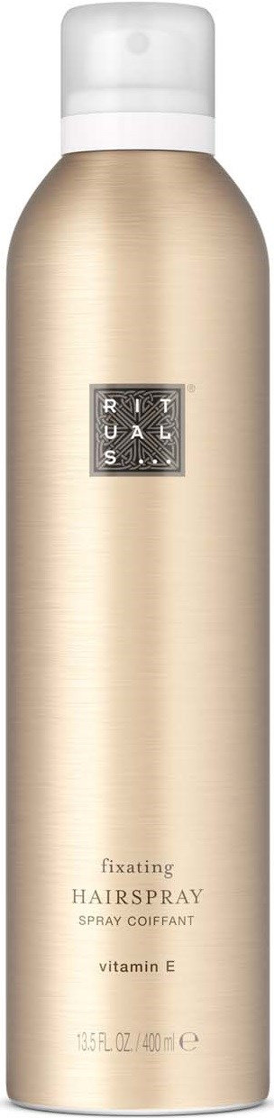 En lång guldfärgad sprayflaska med vit lock, märkt Rituals fixeringshairspray med vitamin E.