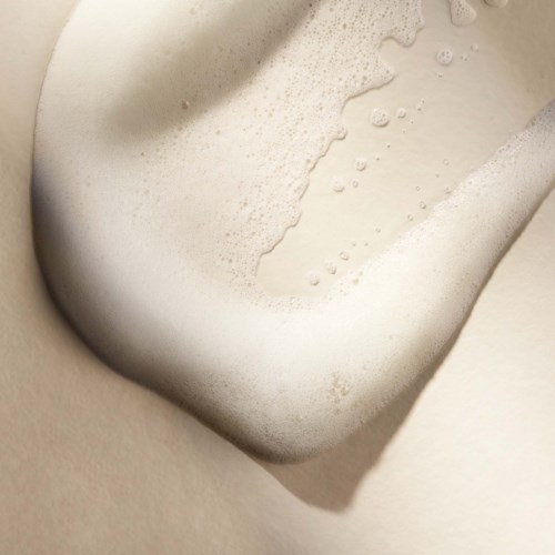 Nahaufnahme einer Toilette mit Seifenschaum im Becken, zeigt eine saubere, weiße Keramikoberfläche.