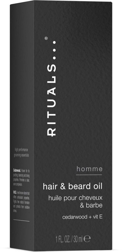 En svart boks av Rituals hår- og skjeggolje med hvit tekst, viser at den inneholder sedertre og vitamin E, 1 fl oz.