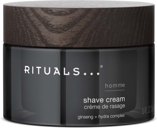 Ett mörkt burk med en trälock, märkt 'RITUALS homme shave cream' med ingredienserna ginseng och hydra complex.