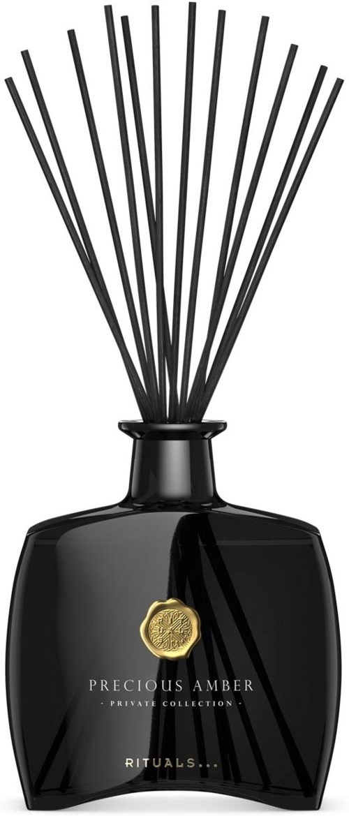 Schwarze Parfüfflasche mit langen, dünnen Stäben und goldenem Emblem, beschriftet 'Precious Amber' von Rituals.