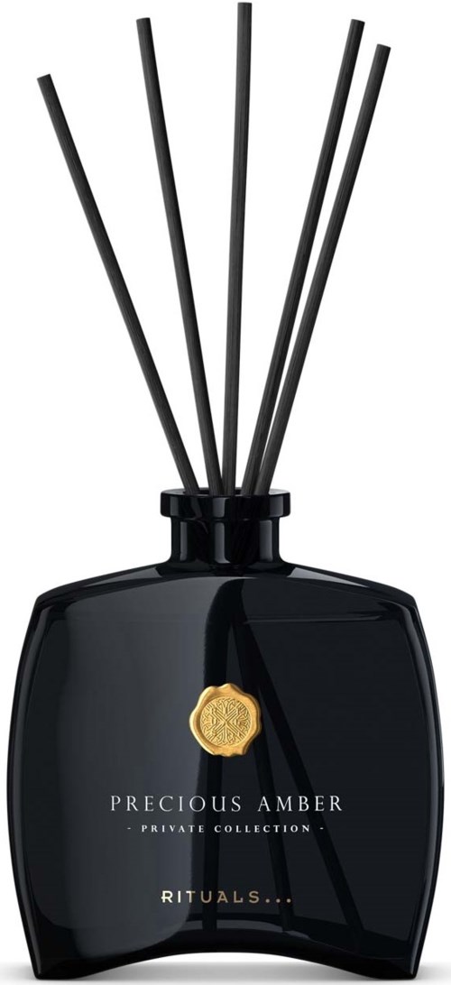 Eine schwarze Parfümzerstäuberflasche mit fünf Stäben und einem goldenen Abzeichen, beschriftet "Precious Amber Rituals."