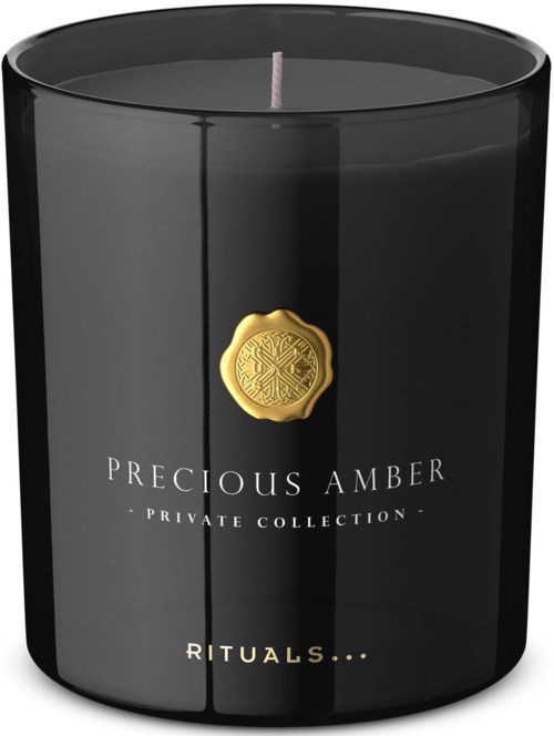 Eine schwarze Luxuskerze mit einem goldenen Emblem und weißen Text, bezeichnet 'Precious Amber' aus einer Privatsammlung.