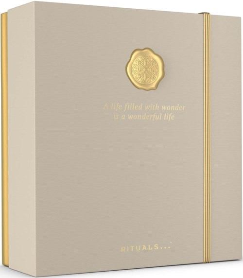 En beige box med gyllene detaljer och ett vaxemblem, med citatet "A life filled with wonder is a wonderful life".