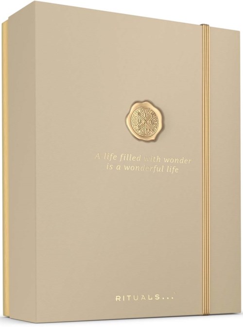Ein beiger Notizbuch mit einem goldenen Emblem und Beschriftung, mit einem passenden Goldgummi.