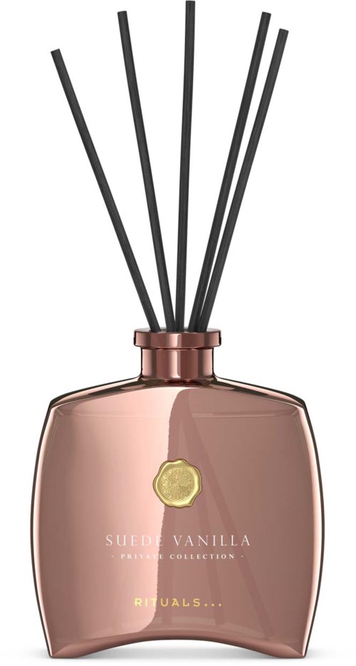 Dekorative Flasche mit schwarzen Stäben innen, beschriftet Sueen Vanilla und Rituals, roségoldene Farbe und gebogene Form.