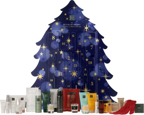En blå juletre med nummererte adventsdører, sølvstjerner og et utvalg av hudpleieprodukter og sokker ved bunnen.