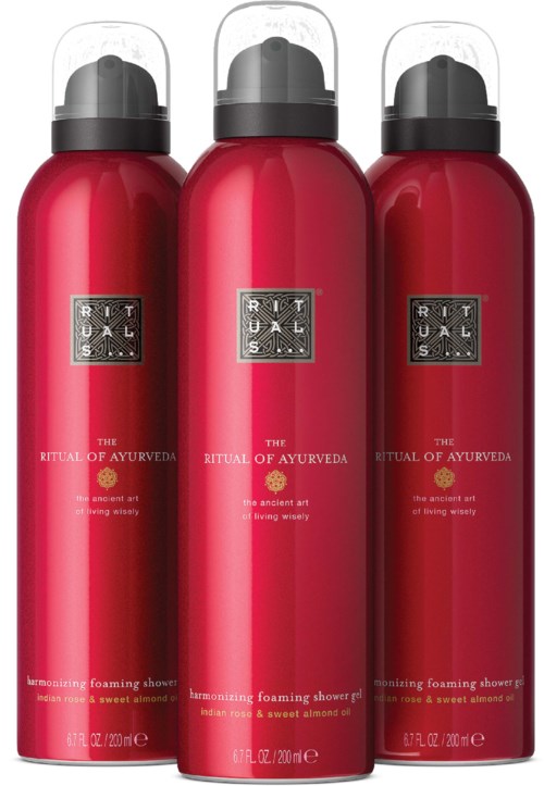 Three red bottles of shower foam with black caps and silver labels, labeled as The Ritual of Ayurveda.