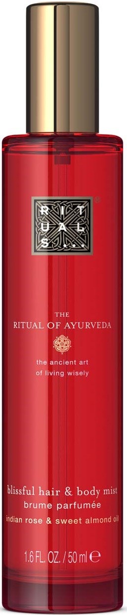 Eine lange rote Flasche mit goldener Kappe, beschriftet 'Rituals' und 'The Ritual of Ayurveda' für Haare und Körper.