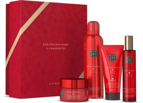 Punainen lahjapakkaus kultakuvioidulla nauhalla ja Rituals-skincare-tuotteita.