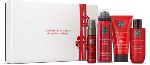 Red skincare products in bottles and tubes with a white gift box and red ribbon, with a quote about happiness.