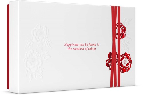 A white box with red ribbon and floral design, featuring the quote: "Happiness can be found in the smallest of things."