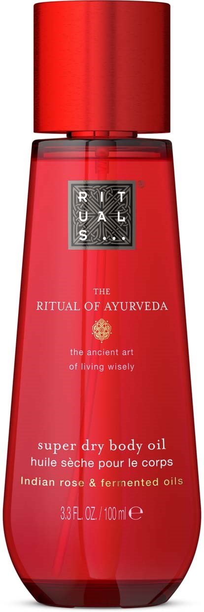 Eine rote Flasche mit Körperöl von Rituals, mit Text über Ayurveda, enthält indisches Rosen- und fermentierte Öle.