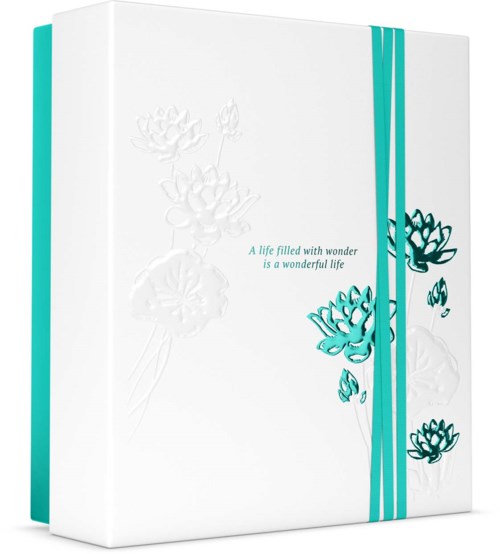 Weiße Notizbuch mit blauer Blumenmuster und Text: "Ein Leben voller Wunder ist ein wundervolles Leben."