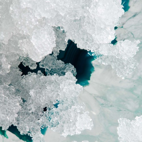 Ice crystals with some darker spaces in the background. Close-up view of frozen ice or snow.