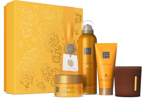 Yellow skincare set with bottles, jars, and a box, featuring botanical designs and gold accents.