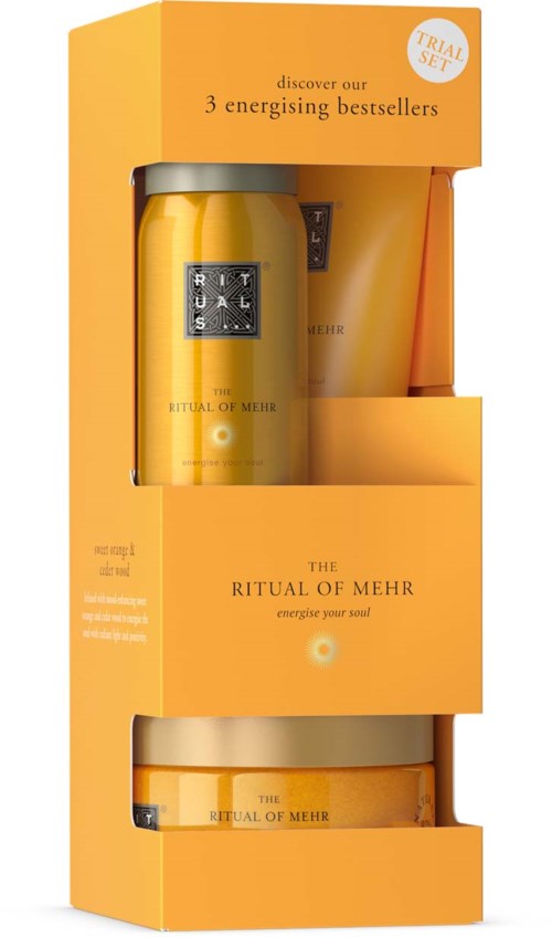Ein Geschenkset mit einer gelben Kerze und Hautpflegeprodukten in einer orangefarbenen Box mit dem Label The Ritual of Mehr, energetisiere deine Seele.