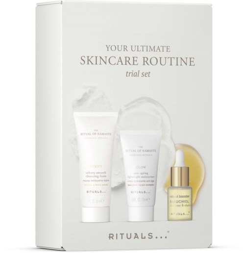 Box mit Hautpflegeprodukten, darunter Reiniger, Feuchtigkeitscreme und Serum in einer gelben Flasche.