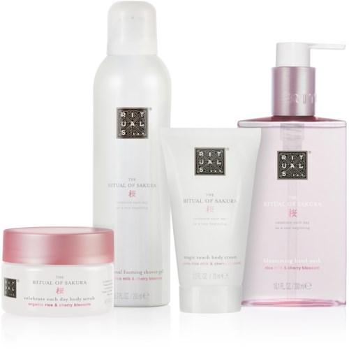 Ett set av vita och rosa hudvårdsprodukter med svarta etiketter, inklusive lotion, kroppsskrubb, kräm och handtvätt.