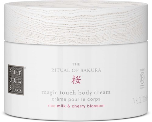 En vit burk med kroppskräm med ett trälock, märkt 'The Ritual of Sakura' med körsbärsblomdoft.