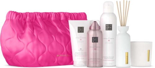 Schönheitsprodukte und eine pinke Tasche, darunter Lotion, Spray, Diffusor und Cremes, ordentlich angeordnet.
