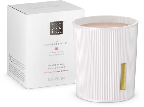 Eine weiße Kerze mit Goldetikett und schönem Karton, als Duftkerze mit Kirschblüten-Aroma gekennzeichnet.