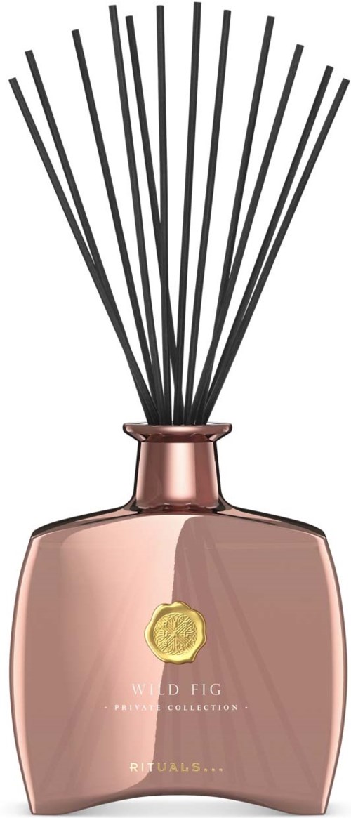 En parfymeflaske i roségull med svarte rørstaver og et gult emblem, merket Wild Fig duft.